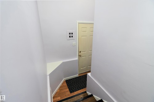 The interior features a staircase with dark treads, light risers, and a light-colored wall - 7720 85 Avenue, Edmonton, AB - Indoor Photo Showing Other Room