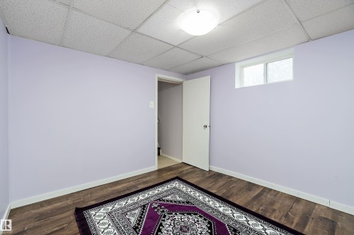Room featuring hardwood flooring, light purple walls, and a recessed window - 7720 85 Avenue, Edmonton, AB - Indoor Photo Showing Other Room