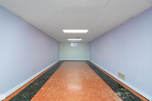 This versatile room features textured walls, a ceiling with recessed lighting, and a window providing natural light - 7720 85 Avenue, Edmonton, AB - Indoor