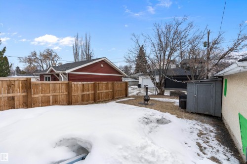 The property includes a wooden fence, a shed, and a fire pit, offering practical outdoor amenities - 7720 85 Avenue, Edmonton, AB - Outdoor
