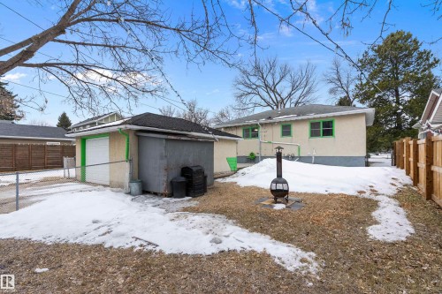 The property features a detached garage with a white garage door, a paved driveway, and a fenced yard - 7720 85 Avenue, Edmonton, AB - Outdoor
