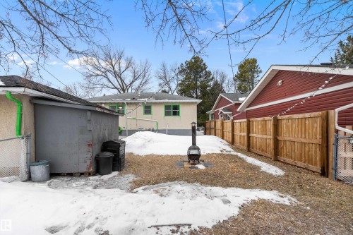 The property features a private yard with a wood fence and a fire pit - 7720 85 Avenue, Edmonton, AB - Outdoor
