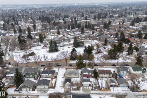 Aerial view of the neighborhood showing a park area with trees and residential properties with garages and snow-covered yards - 7720 85 Avenue, Edmonton, AB - Outdoor With View