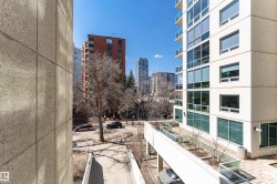 Contemporary high-rise building featuring extensive glass window panels and multiple private balconies with glass railings - 