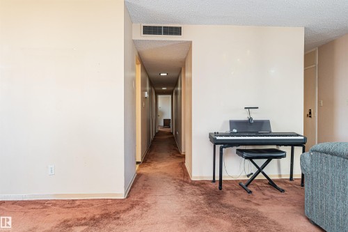 Hallway with neutral wall tones, textured ceiling, and an overhead ventilation system - 407 10045 118 Street, Edmonton, AB - Indoor Photo Showing Other Room
