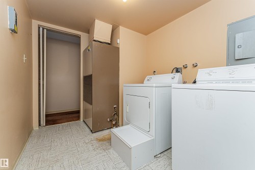 Dedicated laundry area featuring a washer and dryer, utility sink connections, and patterned vinyl flooring - 407 10045 118 Street, Edmonton, AB - Indoor Photo Showing Laundry Room