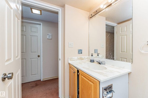 Bathroom vanity featuring a built-in sink, chrome faucet, and wood-finish cabinetry - 407 10045 118 Street, Edmonton, AB - Indoor Photo Showing Bathroom