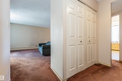 Bi-fold closet doors with round hardware, textured ceiling, and neutral wall paint - 