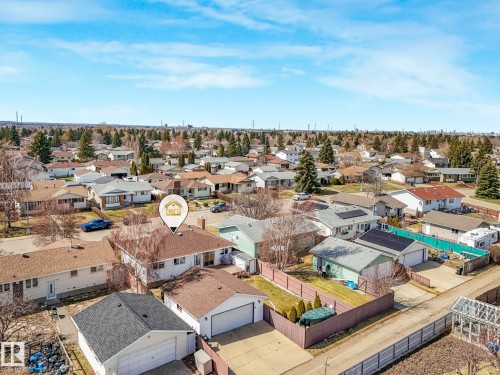 Aerial view highlighting a single-story residence with a brown shingle roof, a detached garage featuring a gray shingle roof, and a fenced backyard - 1027 77 Street, Edmonton, AB - Outdoor With View