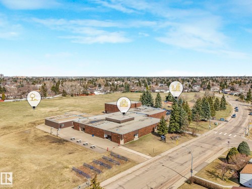 Aerial perspective showcasing a multi-building complex with flat roofs, expansive fields, and surrounding residential areas - 1027 77 Street, Edmonton, AB - Outdoor With View