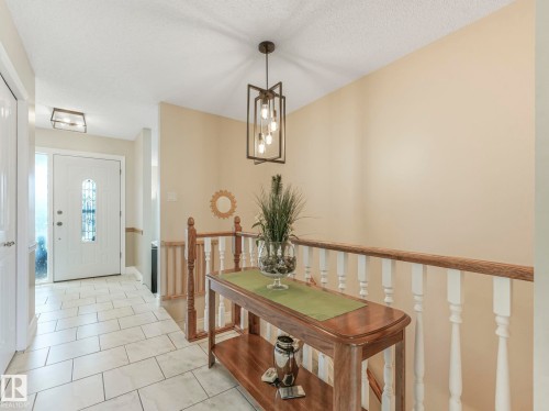 Entryway featuring light-colored rectangular tile flooring, a white front door with decorative glass inserts, and a sidelight - 1027 77 Street, Edmonton, AB - Indoor Photo Showing Other Room