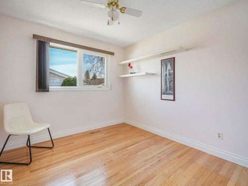 Light wood-finish flooring complements white walls and trim - 1027 77 Street, Edmonton, AB - Indoor Photo Showing Other Room
