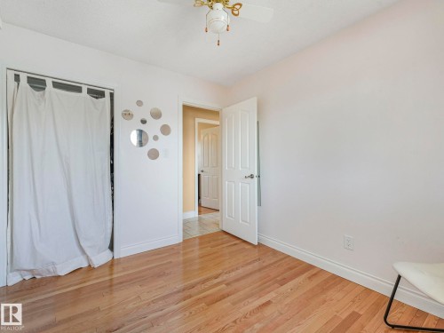 Bright room featuring wood-finish flooring, white baseboards, and a ceiling fan - 1027 77 Street, Edmonton, AB - Indoor