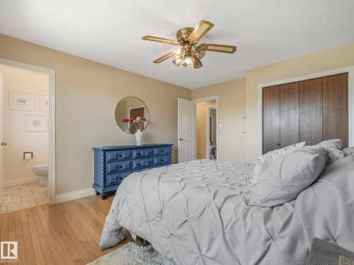 Bedroom featuring wood-finish flooring, a ceiling fan with integrated lighting, and a closet with bifold doors - 1027 77 Street, Edmonton, AB - Indoor Photo Showing Bedroom