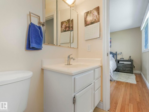 Bathroom vanity featuring an integrated sink, polished chrome faucet, and mirrored medicine cabinet - 1027 77 Street, Edmonton, AB - Indoor Photo Showing Bathroom