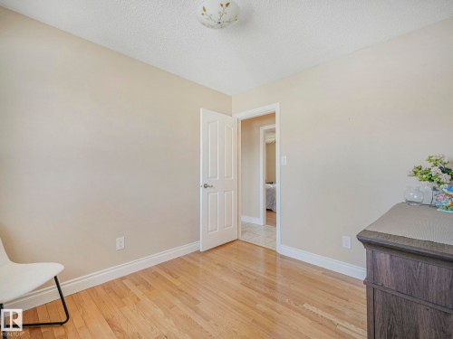 Neutral-toned room featuring light wood-finish flooring and white baseboards - 1027 77 Street, Edmonton, AB - Indoor Photo Showing Other Room