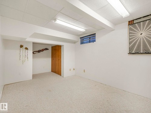 Carpeted room featuring white painted walls and a drop-panel ceiling - 1027 77 Street, Edmonton, AB - Indoor Photo Showing Other Room
