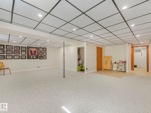 Spacious finished lower level featuring recessed lighting, a drop ceiling, light-toned carpeting, and a separate tiled area - 1027 77 Street, Edmonton, AB - Indoor Photo Showing Other Room