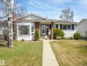 Ranch-style residence featuring white siding, a prominent bay window, brick accents, dark window shutters, and a concrete front walkway - 1027 77 Street, Edmonton, AB  - Outdoor With Facade 