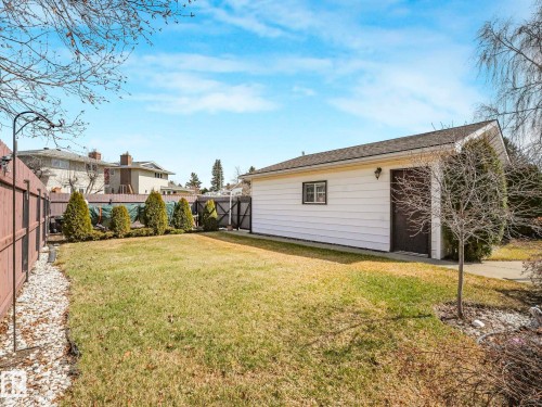 Detached garage with horizontal siding, a brown overhead door, and a single window - 1027 77 Street, Edmonton, AB - Outdoor