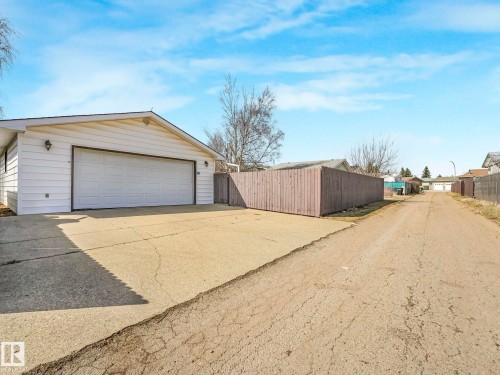 Detached garage with white vinyl siding and a wide driveway - 1027 77 Street, Edmonton, AB - Outdoor