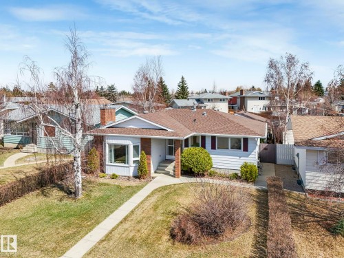 Single-story residence featuring light-colored siding, a brown shingle roof, and brick detailing - 1027 77 Street, Edmonton, AB - Outdoor With Facade