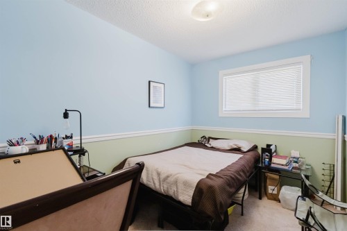 Bedroom featuring a single window with blinds, two-tone painted walls, ceiling-mounted light fixture, and carpet flooring - 10519 36A Avenue, Edmonton, AB - Indoor Photo Showing Bedroom