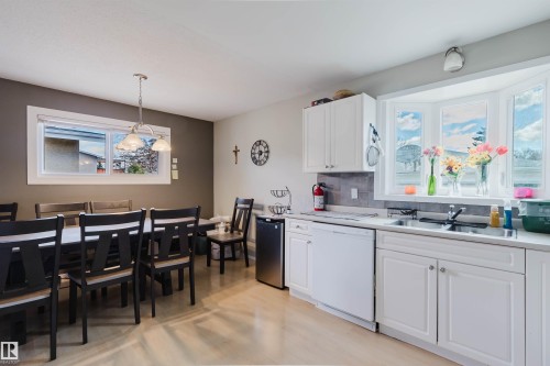Kitchen area with white cabinetry, a double basin sink, and a bay window - 10519 36A Avenue, Edmonton, AB - Indoor