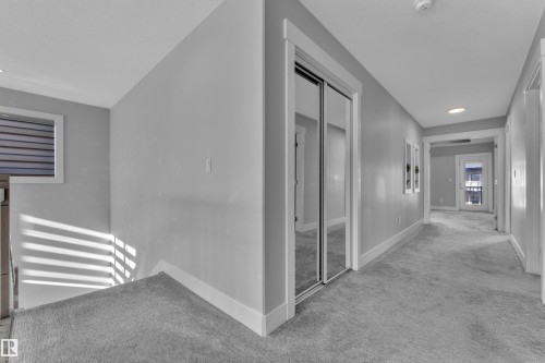 Carpeted hallway featuring a mirrored closet, recessed lighting, and a window with horizontal blinds - 4403 Triomphe Gate, Beaumont, AB - Indoor Photo Showing Other Room