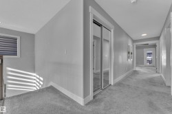 Carpeted hallway featuring a mirrored closet, recessed lighting, and a window with horizontal blinds - 