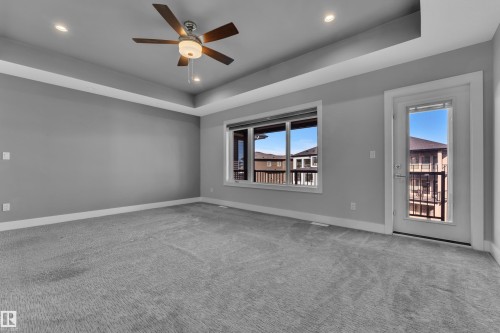 Spacious room featuring tray ceilings, recessed lighting, and soft gray carpeting - 4403 Triomphe Gate, Beaumont, AB - Indoor Photo Showing Other Room