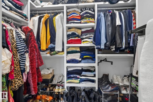 Custom-designed closet system featuring white shelving, multiple hanging rods, and dedicated shoe storage - 3605 42 Avenue, Beaumont, AB - Indoor With Storage