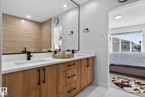Modern bathroom vanity featuring dual integrated sinks set in a white countertop - 3605 42 Avenue, Beaumont, AB - Indoor Photo Showing Bathroom