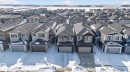Contemporary residential streetscape featuring numerous two-story homes with attached garages, dark shingle roofing, and light-toned siding - 3605 42 Avenue, Beaumont, AB  -  With Facade 