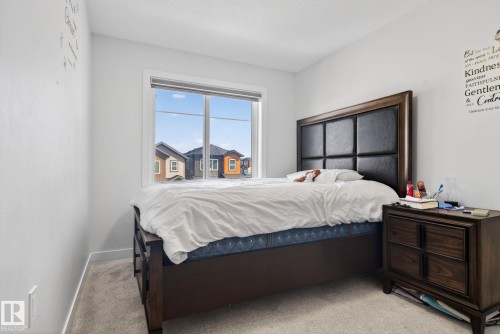 Bright room featuring a large window, light gray walls, and neutral-toned carpeting - 3605 42 Avenue, Beaumont, AB - Indoor Photo Showing Bedroom