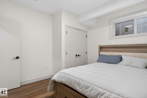 Bedroom featuring warm wood-finish flooring, crisp white walls, and a recessed window with a white frame - 3605 42 Avenue, Beaumont, AB - Indoor Photo Showing Bedroom