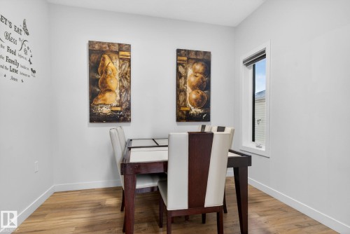 Dining area featuring wood-finish flooring, white baseboards, a single casement window, and neutral wall tones - 3605 42 Avenue, Beaumont, AB - Indoor Photo Showing Dining Room