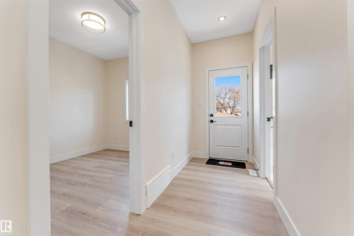 Entryway featuring light wood-finish flooring, white walls, and a glass-paneled door - 10323 79 Street, Edmonton, AB - Indoor Photo Showing Other Room