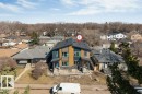 Modern twin-home with multi-pane windows, distinct entryways, and a dark shingle roof, complemented by a mix of horizontal siding and paneling - 10323 79 Street, Edmonton, AB  - Outdoor 