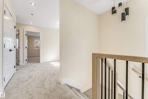 Upper-level landing featuring light gray carpeting, recessed ceiling lighting, and a modern chandelier with multiple pendant lights - 10323 79 Street, Edmonton, AB - Indoor Photo Showing Other Room