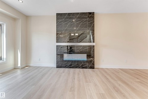 Contemporary fireplace with dark marbled tile surround - 10323 79 Street, Edmonton, AB - Indoor With Fireplace