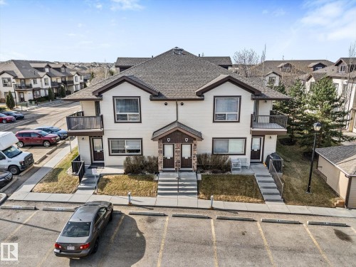 Multi-level residential building featuring light-colored siding and dark trim - 86 604 62 Street, Edmonton, AB - Outdoor With Facade