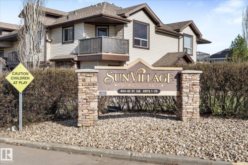 Entryway featuring stone veneer accents, dark panel doors with integrated glass, and horizontal siding - 86 604 62 Street, Edmonton, AB - Outdoor With Exterior