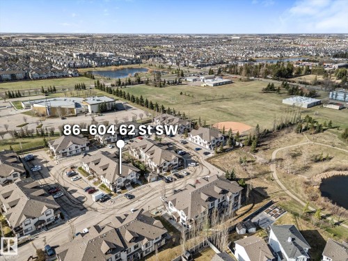Aerial perspective showcasing a residential community with multi-family dwellings and single-family homes - 86 604 62 Street, Edmonton, AB - Outdoor With View