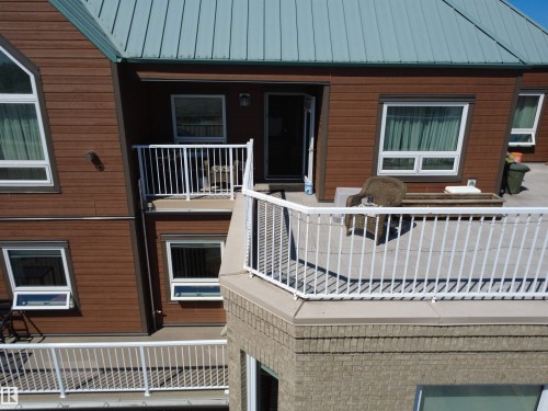 Multi-level exterior featuring brown wood-finish siding and a light blue metal roof - 410 9926 100 Avenue, Fort Saskatchewan, AB - Outdoor With Exterior