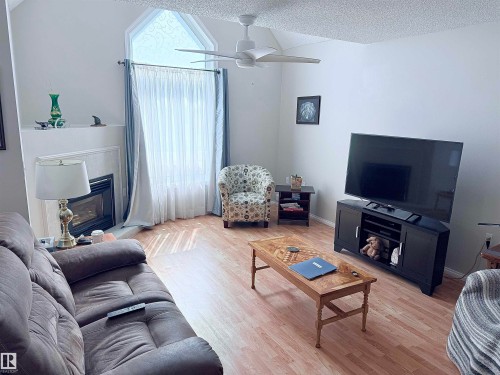 Living area featuring a vaulted ceiling and a ceiling fan - 410 9926 100 Avenue, Fort Saskatchewan, AB - Indoor Photo Showing Living Room With Fireplace