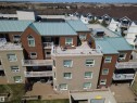 Multi-level residential building featuring various exterior finishes, including textured stucco and wood-finish siding - 410 9926 100 Avenue, Fort Saskatchewan, AB  - Outdoor 