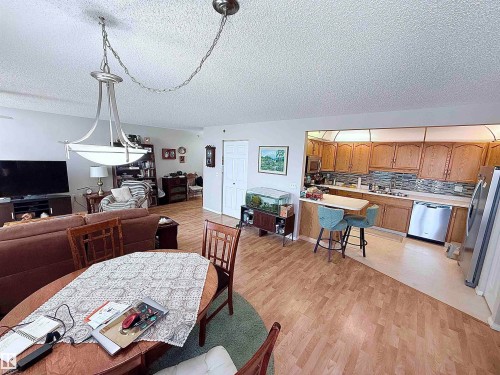 Open-concept living space featuring wood-finish flooring throughout - 410 9926 100 Avenue, Fort Saskatchewan, AB - Indoor Photo Showing Dining Room