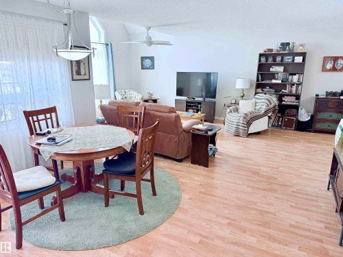 Open-concept living area featuring wood-finish flooring throughout - 410 9926 100 Avenue, Fort Saskatchewan, AB - Indoor