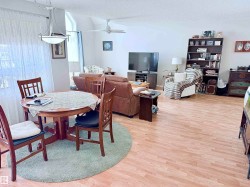 Open-concept living area featuring wood-finish flooring throughout - 
